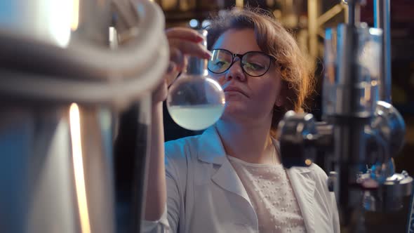 Portrait of Woman Researcher Holding Flask with Liquid in Scientific Laboratory alt