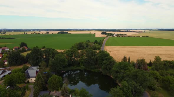 small lake on country, cars driving on road.Great aerial view flight sinking down drone footageof alt