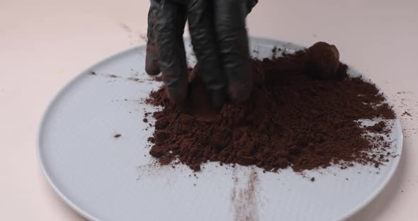 Handmade Organic Chocolate Truffles Falling Into Cocoa Powder Closeup of a Pastry Chef's Hand Slow