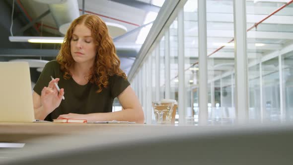 Businesswoman writing on sticky note at desk 4k alt