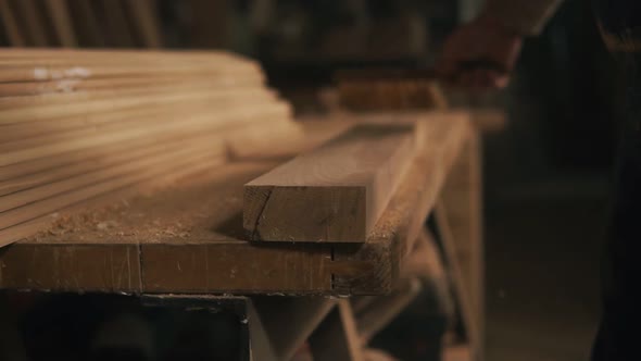 The Man Brushes Away the Shavings and Wood Dust From the Rail alt
