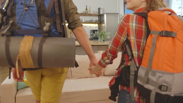 Cheerful Couple of Backpack Travelers Moving in Rented Accommodations alt