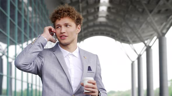 Young Handsome Businessman Talking on Mobile Phone Outside