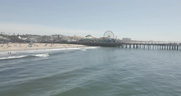 A unique perspective of the Santa Monica Pier as seen from the ocean. Many people out enjoying food, alt