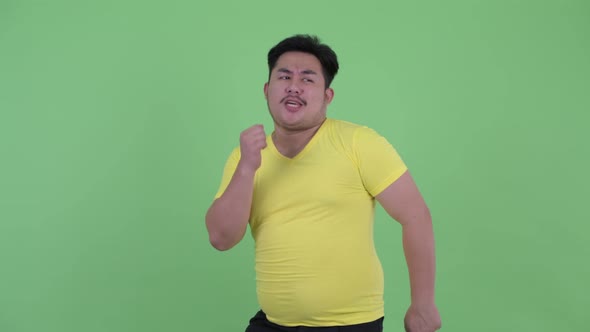 Happy Young Overweight Asian Man Dancing alt