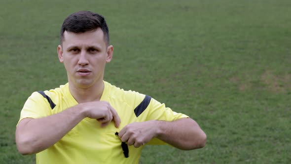 Football Soccer referee whistles and shows penalty and yellow, red card. alt