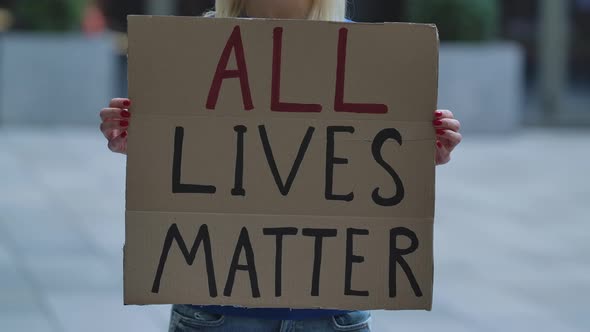 ALL LIVES MATTER on a Cardboard Poster in the Hands of White Female Protester Activist. Closeup of alt