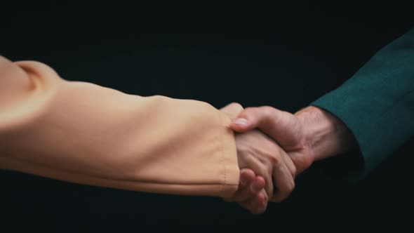 Two Businessmen Shake Hands on a Black Background Good Deal alt