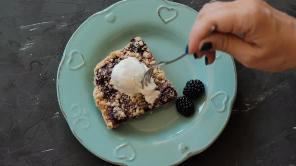 Piece of cake with blackberries and ice cream on a blue plate alt