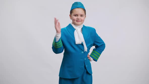 Funny Dance of Shy Girl in Stewardess Uniform at White Background alt