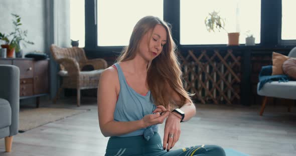 Young Sporty Beautiful Blonde Woman Preparing To Do Fithess Sports at Home, Doing Hair. Healthy alt