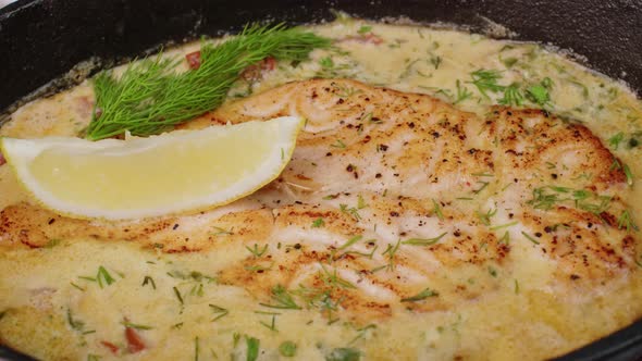 Fish Fillet Cooked in Cream Sauce Spining Round in Metal Pan