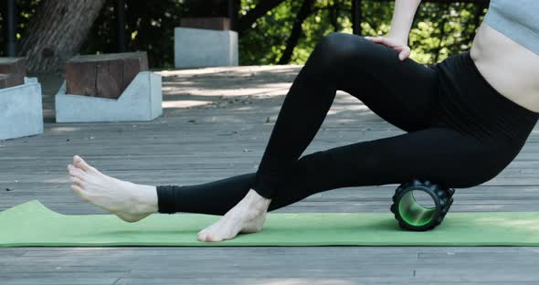 Girl on Yoga Mat Massages the Thigh Muscles with an MFR Roller alt