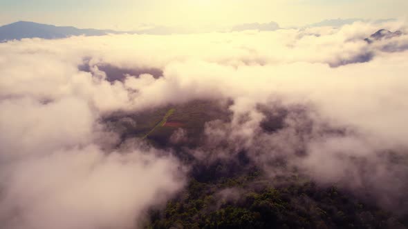 Aerial view from a drone over mountain fog during sunrise alt