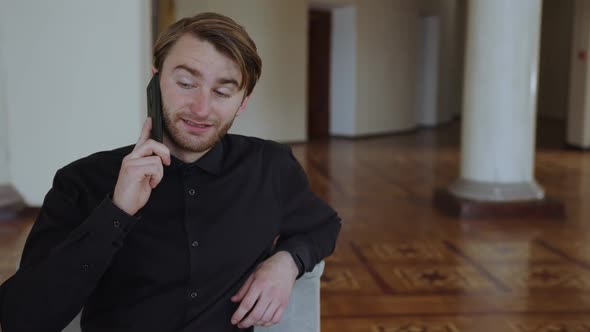 A Man is Talking on the Phone with His Friend About Last Night alt