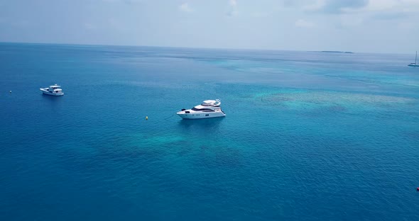 Tropical above island view of a sunshine white sandy paradise beach and blue ocean background in 4K alt