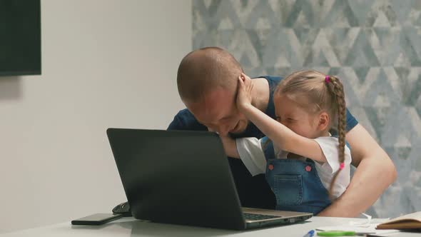Little Girl Shakes Father Head Having Fun Near Modern Laptop alt