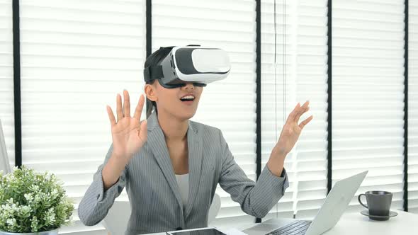 Asian woman use virtual reality glasses ( VR ) in her office