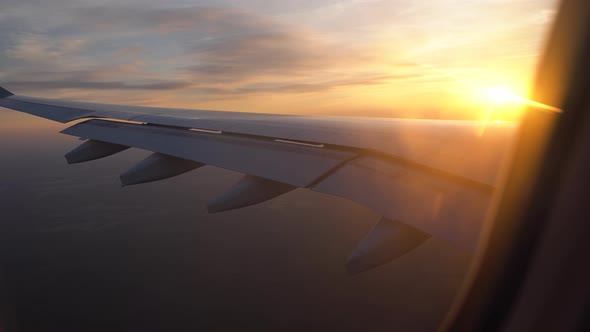 Sunset in the Window of the Plane. Beautiful View of the Aircraft Wing. Passenger Transportation and alt