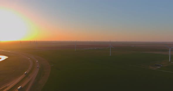 Road Leading to view of the Texas wind turbine farms in the beautiful sky during sunset showing alt