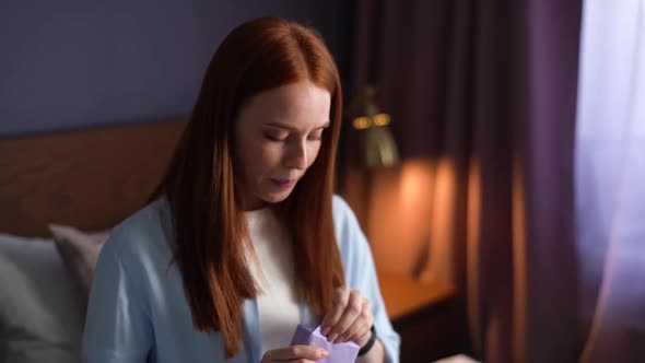 Close-up Face of Happy Excited Young Woman Opening Gift Box with Present at Cozy Living Room alt