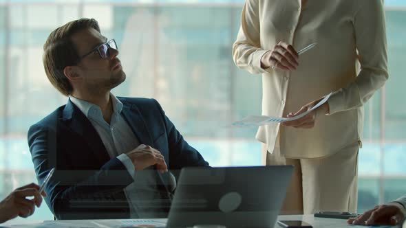Mature professional company leader working sitting at boardroom table in office alt