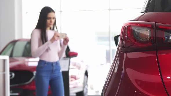Woman Taking Photos of a Car with Her Smart Phone alt