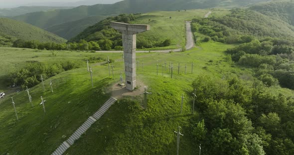 Dolly in aerial shot of a historical monument in the Didgori Valley, Georgia. alt