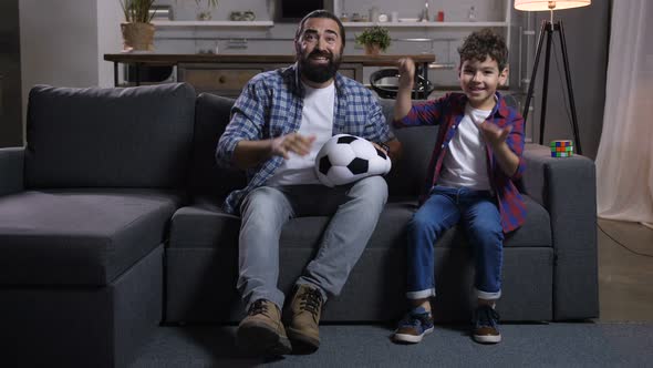 Emotional Father and Son Watching Sports on Tv alt