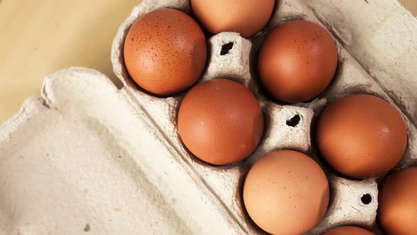 Hicken Eggs in a Package on a Wooden Table Rotate Overhead View