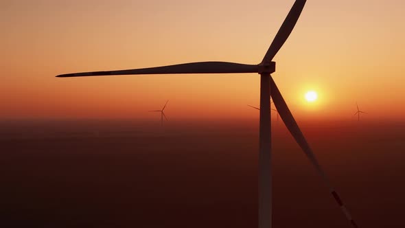 Offshore Windmills Rotate Against Sunset Producing Energy