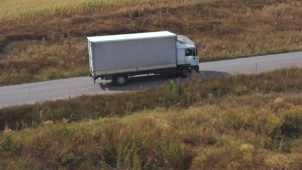 Aerial Shot of Truck with Cargo Trailer Driving on Road and Transporting Goods. Flying Over Delivery alt