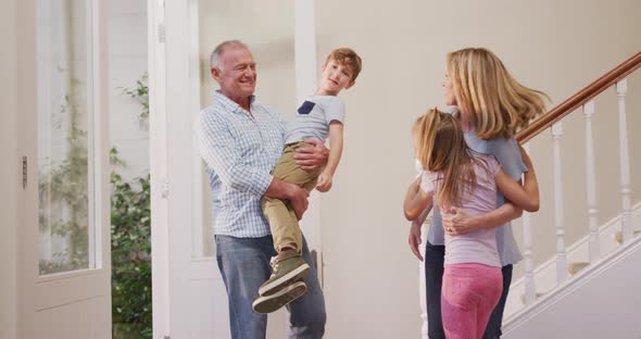 Senior Caucasian couple with grandchildren spending time at home together alt