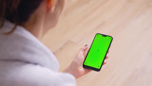 Young Female Using Smart Phone Sitting On Sofa At Home.