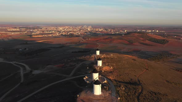 Aerial view of windmills in the countryside in Spain at sunrise alt