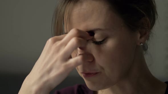 Portrait of a Woman Rubbing Her Eyes and the Bridge of Her Nose alt