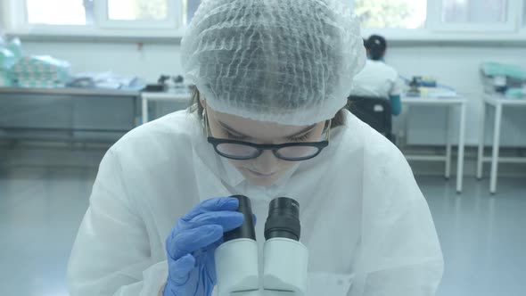 Scientist Working with Microscope in Manufacturing Laboratory