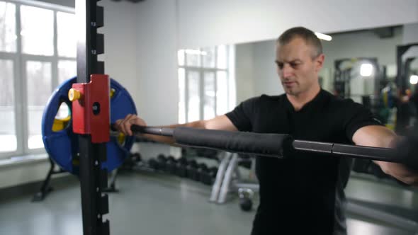 A Strong Man Fits the Barbell Takes It on the Shoulders and Does Squats  Slow Mo alt