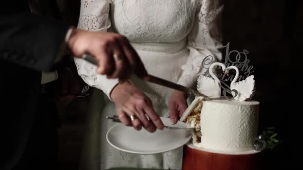 bride and groom cutting wedding cake with a knife