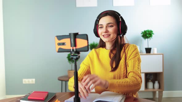 Happy Young Teacher in Headphones Communicates By Video Call Using Mobile Phone alt