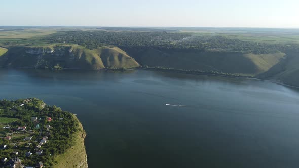 Aerial view of wide Dnister river and distant rocky hills in Bakota area, part of the National park,