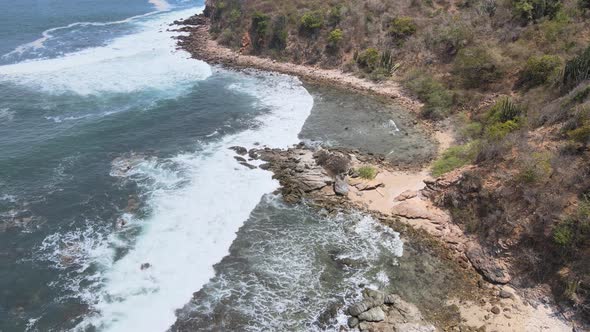 Drone flying over a rocky island of Ixtapa located in the state of Guerrero, Mexico during a sunny d alt