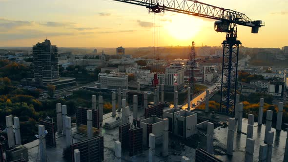 High-rise Building in Progress with Machinery at Sunset. Modern Construction Site at Sunset, Aerial alt