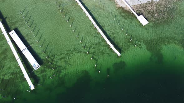 Top down view of snow covered docks in a partly frozen lake.