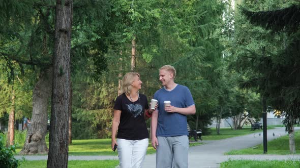 Mature Woman with Adult Son Walking in a Park alt