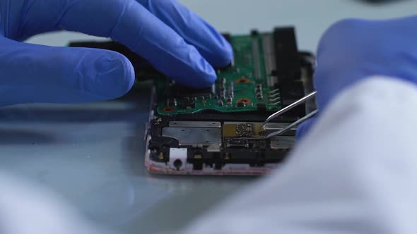 Criminal Expert Removing Microboard From Burned Mobile Phone, Investigation alt