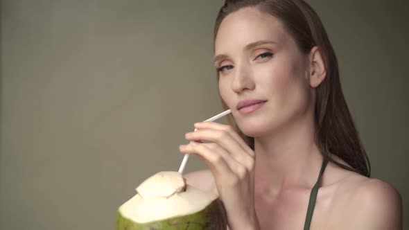 Beautiful happy woman posing with tropical coconut.