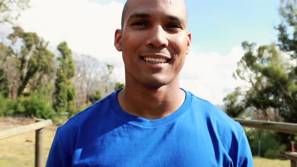 Smiling fit man standing in park alt