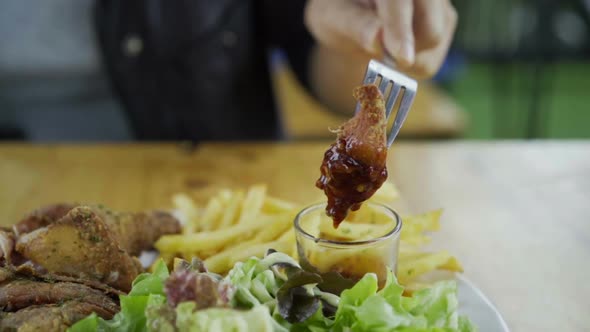 slow-motion of fried chicken with sauce for dipping on a fork