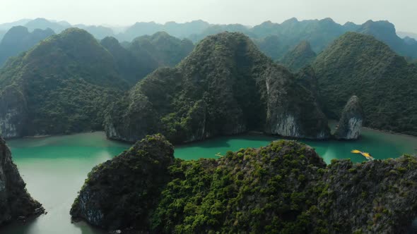Aerial: flying over Ha Long Bay rock pinnacles, famous tourism destination in Vietnam alt